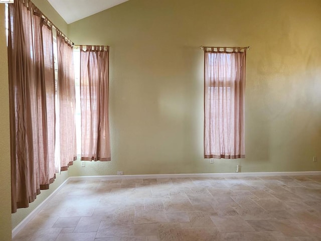 empty room featuring lofted ceiling