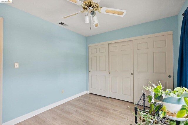 bedroom with ceiling fan, a closet, and light hardwood / wood-style flooring