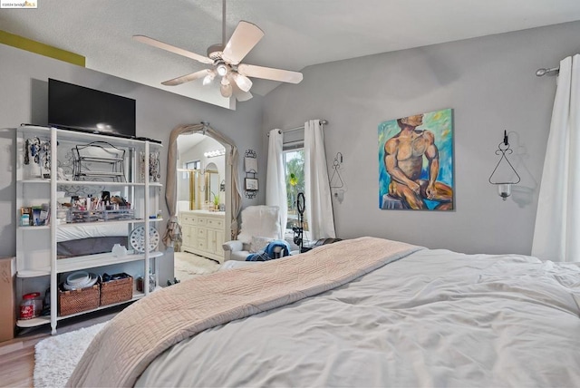 bedroom featuring wood-type flooring, vaulted ceiling, connected bathroom, and ceiling fan