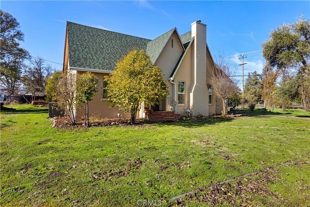 view of property exterior with a yard, a chimney, roof with shingles, and stucco siding