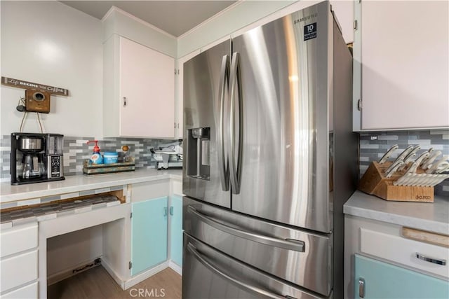 kitchen featuring light countertops, tasteful backsplash, and stainless steel fridge with ice dispenser