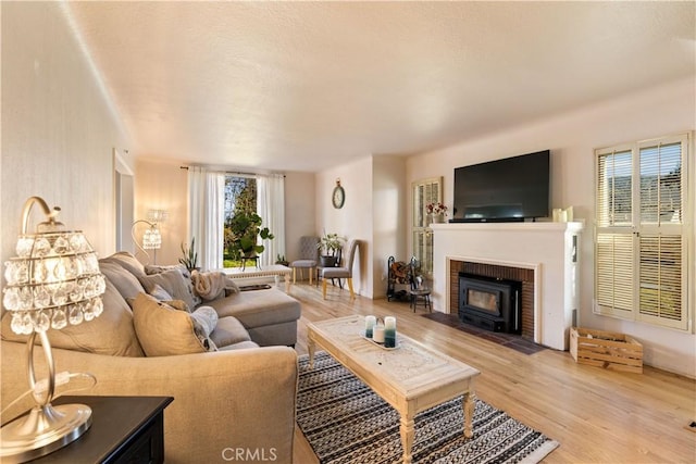 living room with a brick fireplace and light wood-style flooring