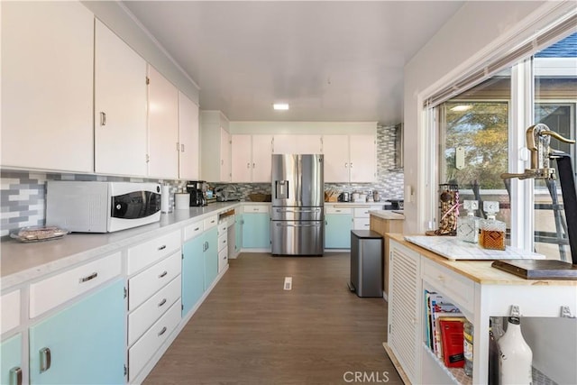 kitchen featuring tasteful backsplash, dark hardwood / wood-style floors, white cabinets, and white appliances