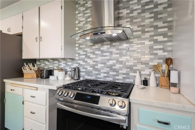 kitchen featuring stainless steel appliances, white cabinetry, decorative backsplash, and range hood