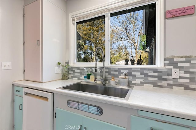 kitchen with dishwasher, sink, dishwashing machine, white cabinets, and decorative backsplash