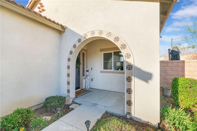 view of exterior entry with a patio