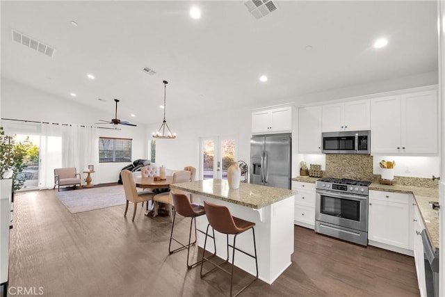 kitchen with french doors, white cabinetry, light stone counters, an island with sink, and stainless steel appliances