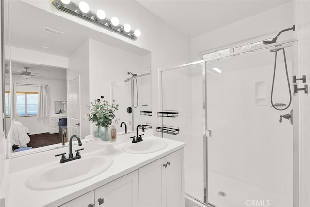 bathroom featuring ceiling fan, vanity, and a shower with shower door