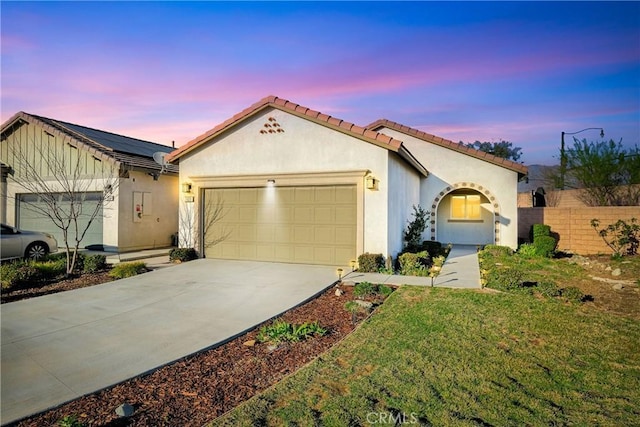 mediterranean / spanish-style home featuring a garage and a lawn