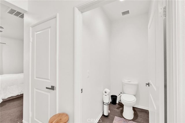 bathroom featuring hardwood / wood-style flooring and toilet