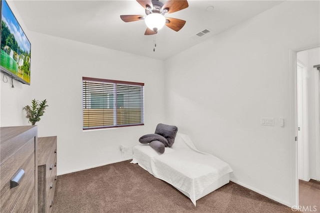 sitting room with ceiling fan and dark carpet