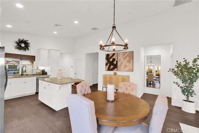 dining space with a notable chandelier, sink, and dark hardwood / wood-style floors