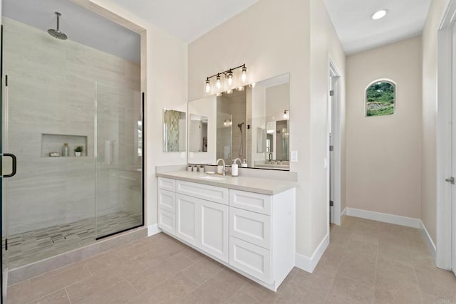 bathroom with a shower with shower door, vanity, and tile patterned flooring