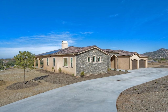 mediterranean / spanish-style home with a garage and a mountain view