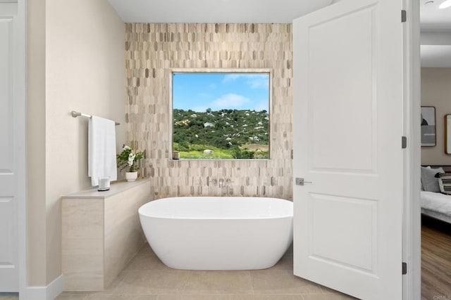 bathroom with tile patterned flooring and a tub to relax in