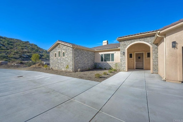 view of front of property featuring a mountain view and a patio