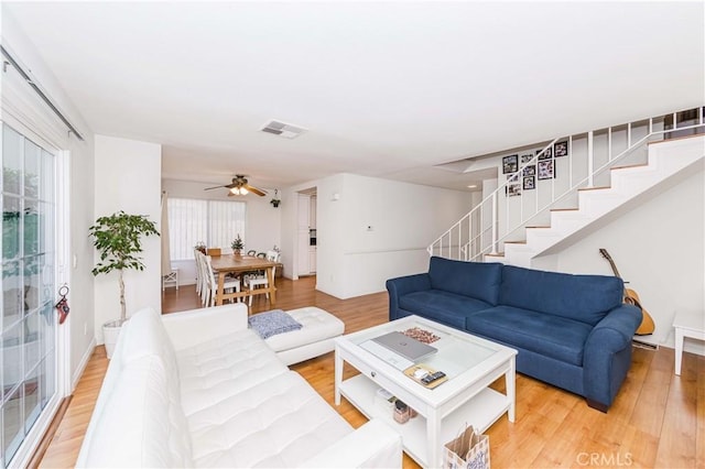 living room featuring ceiling fan and light hardwood / wood-style floors