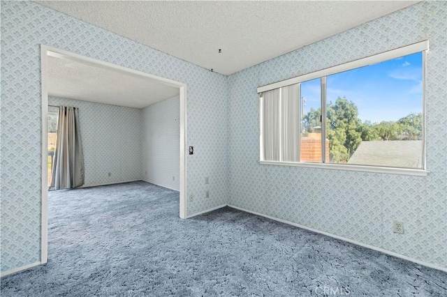 carpeted spare room with a textured ceiling