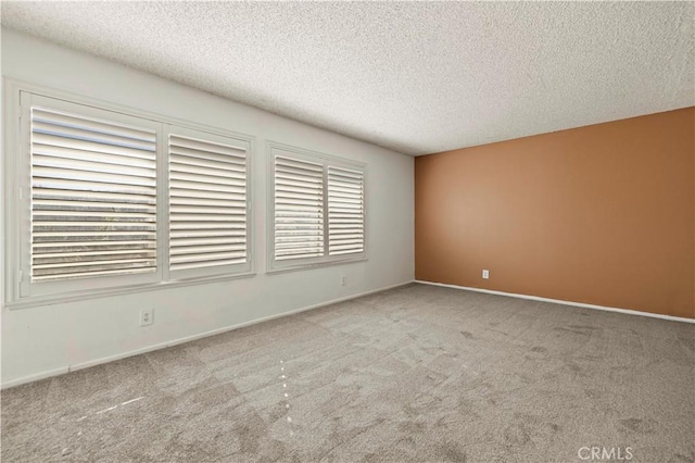 carpeted empty room featuring a textured ceiling