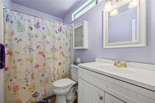 bathroom with toilet, vanity, and a shower with curtain