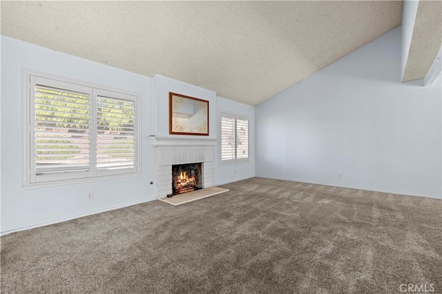 unfurnished living room featuring vaulted ceiling, a brick fireplace, and carpet floors