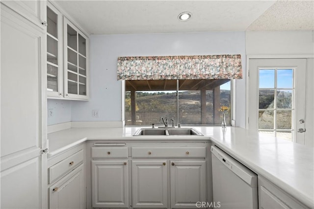 kitchen featuring a wealth of natural light, white cabinetry, dishwasher, and sink