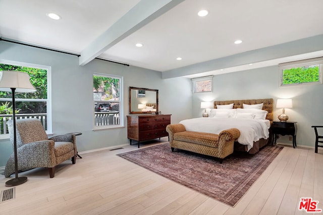 bedroom with light hardwood / wood-style flooring and beamed ceiling