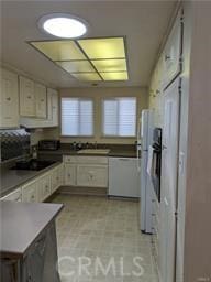 kitchen with white dishwasher, sink, and white cabinets