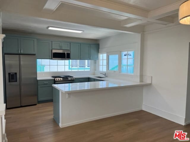 kitchen with hardwood / wood-style floors, stainless steel appliances, sink, kitchen peninsula, and beam ceiling