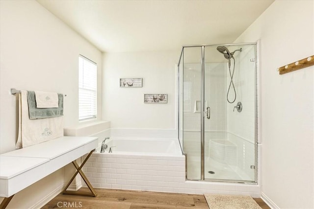 bathroom with a garden tub, wood finished floors, and a shower stall