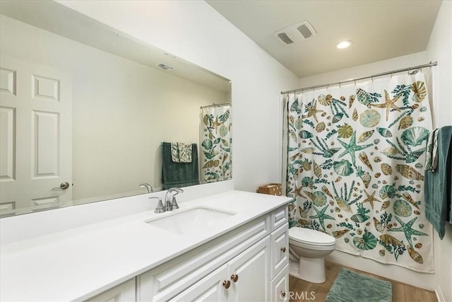 bathroom with vanity, a shower with shower curtain, wood finished floors, visible vents, and toilet