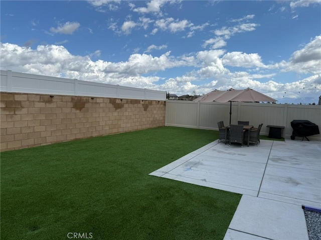 view of yard featuring a fenced backyard, outdoor dining area, and a patio