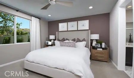 bedroom with ceiling fan and ensuite bath