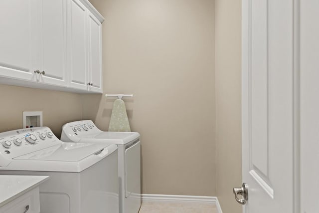 laundry area with separate washer and dryer and cabinets