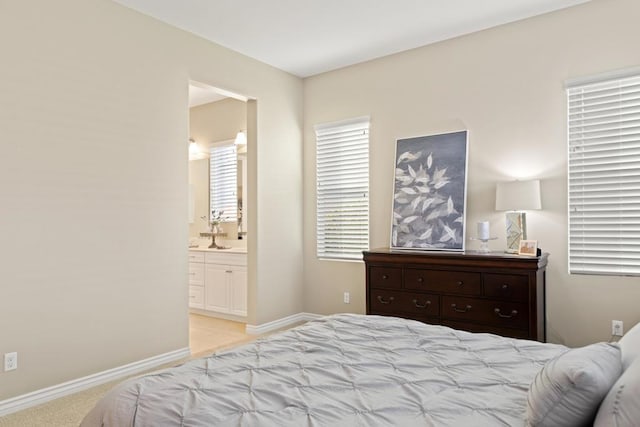 bedroom featuring light colored carpet and ensuite bath