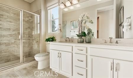 bathroom with toilet, vanity, tile patterned flooring, and a shower with door