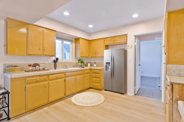 kitchen featuring sink, stainless steel fridge with ice dispenser, and light hardwood / wood-style flooring