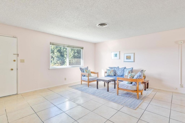 living area featuring light tile patterned floors and a textured ceiling