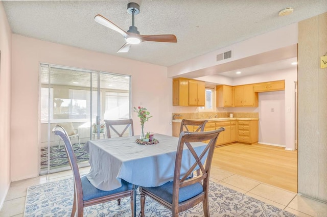 tiled dining room featuring ceiling fan and a textured ceiling