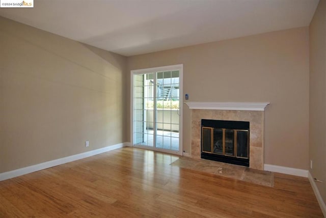 unfurnished living room featuring wood-type flooring and a premium fireplace