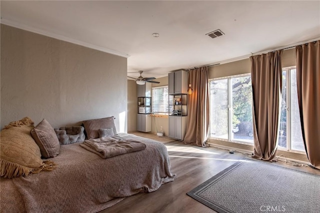 bedroom featuring ceiling fan, ornamental molding, light hardwood / wood-style floors, and multiple windows