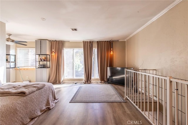 bedroom with hardwood / wood-style flooring, ornamental molding, and ceiling fan