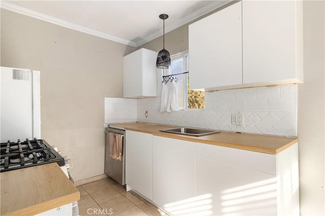 kitchen with decorative light fixtures, dishwasher, white cabinets, ornamental molding, and light tile patterned floors