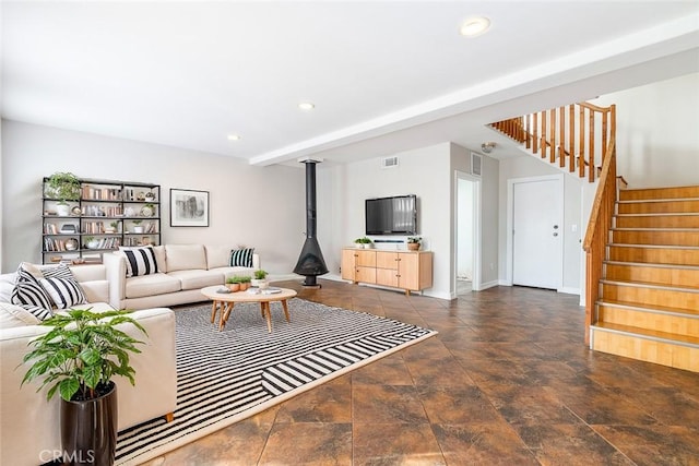 living room featuring a wood stove and beamed ceiling