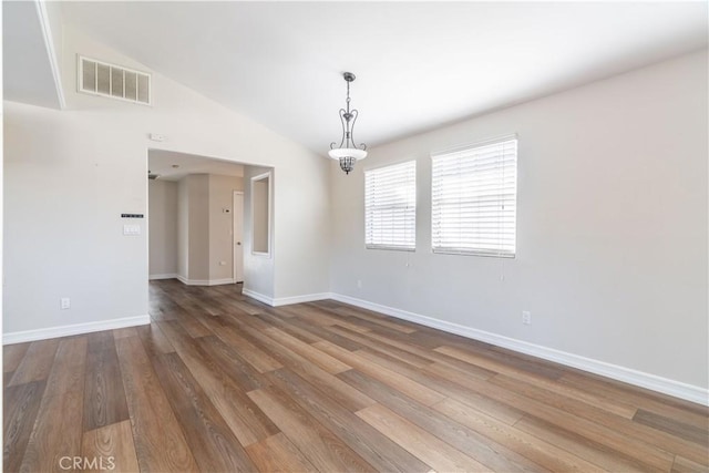 spare room with hardwood / wood-style floors and lofted ceiling