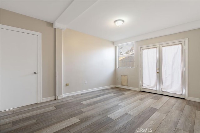 empty room featuring light hardwood / wood-style floors and french doors