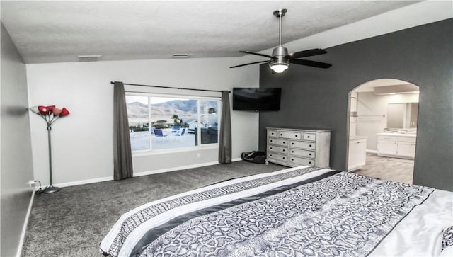 bedroom featuring visible vents, lofted ceiling, arched walkways, baseboards, and ceiling fan