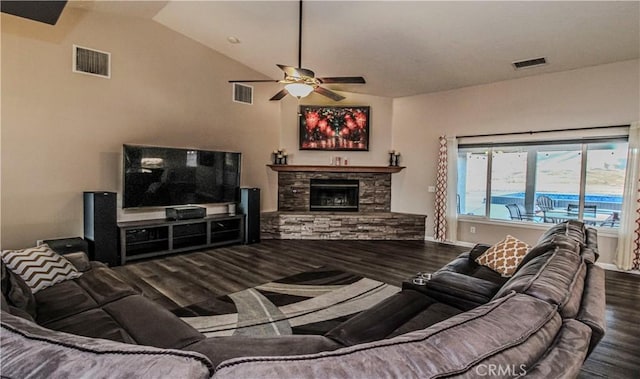 living area with a stone fireplace, wood finished floors, and visible vents