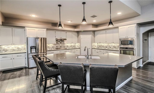 kitchen featuring visible vents, a sink, white cabinetry, stainless steel appliances, and dark wood-style flooring