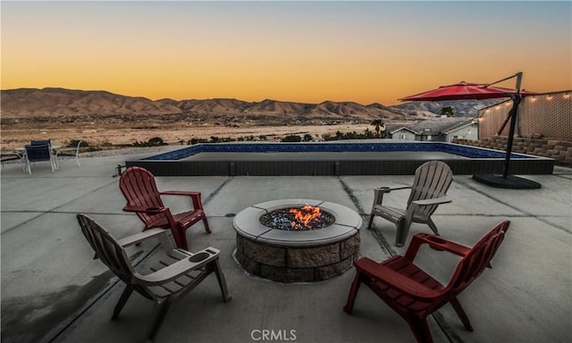 view of patio / terrace with an outdoor pool, a mountain view, and an outdoor fire pit